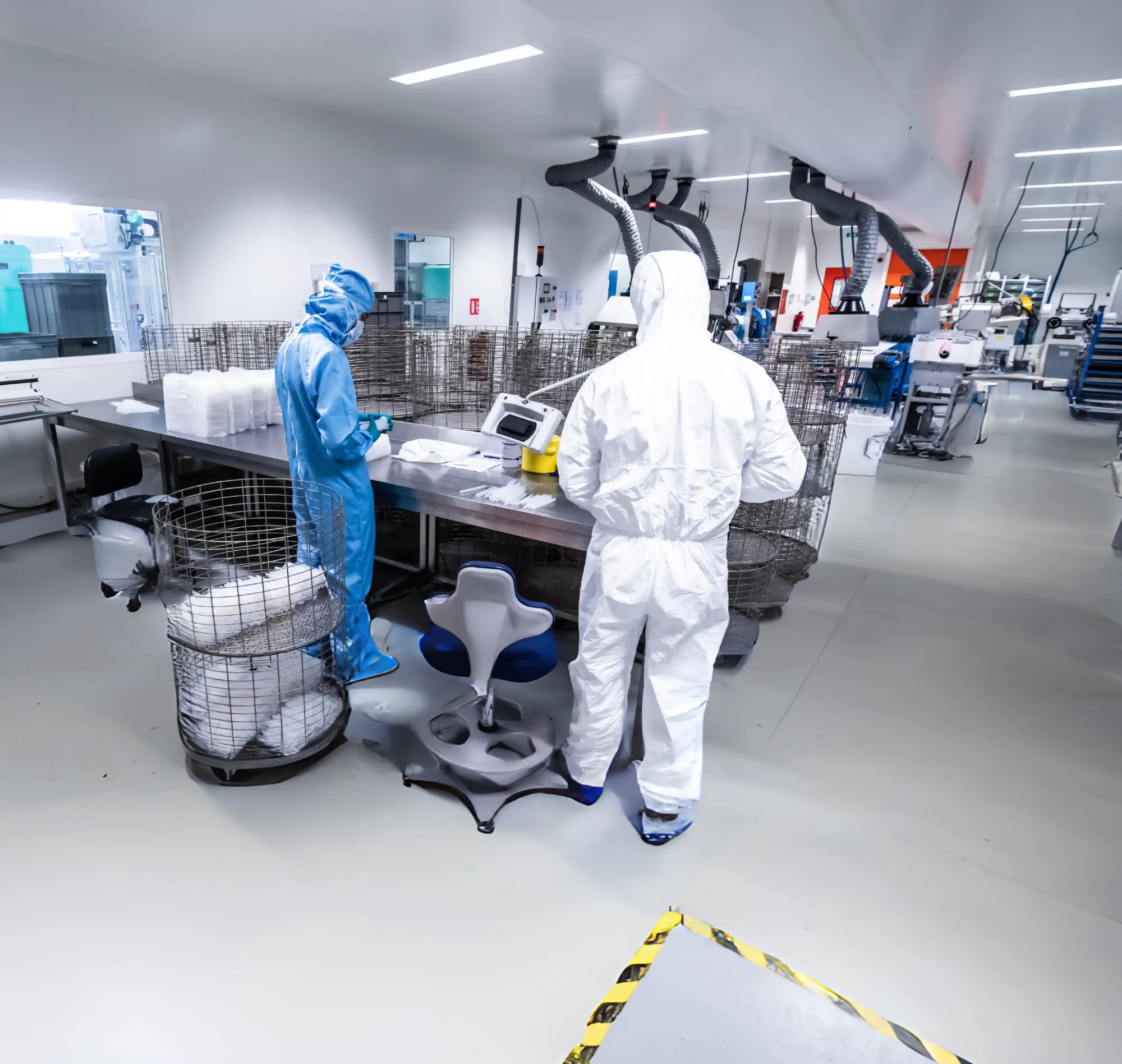 Sala blanca ISO 8 de Progress Silicones · operarios revisando piezas sobre mesa de inspección